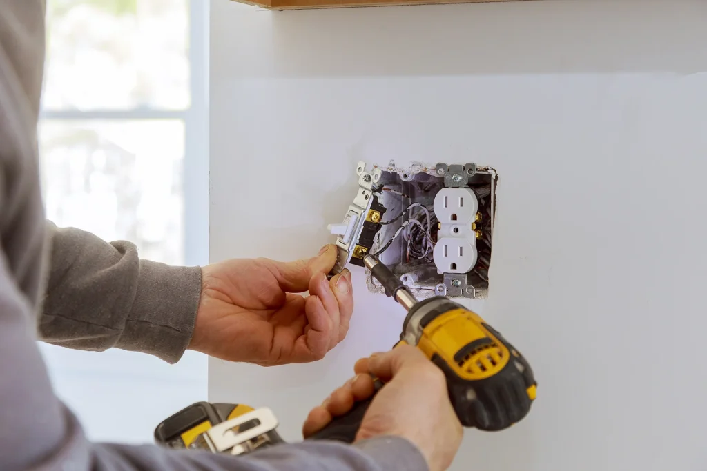 Electrician installing outlet and switch